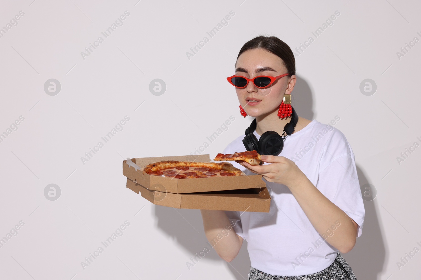 Photo of Woman in sunglasses with delicious pizza on white background, space for text