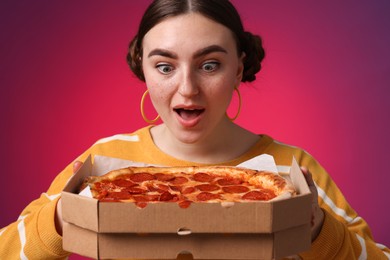 Surprised woman with delicious pizza on bright background