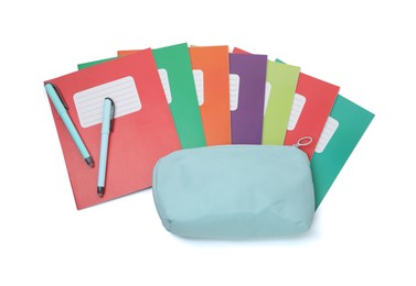 Photo of Colorful copybooks, pencil case and pens isolated on white, top view. School stationery