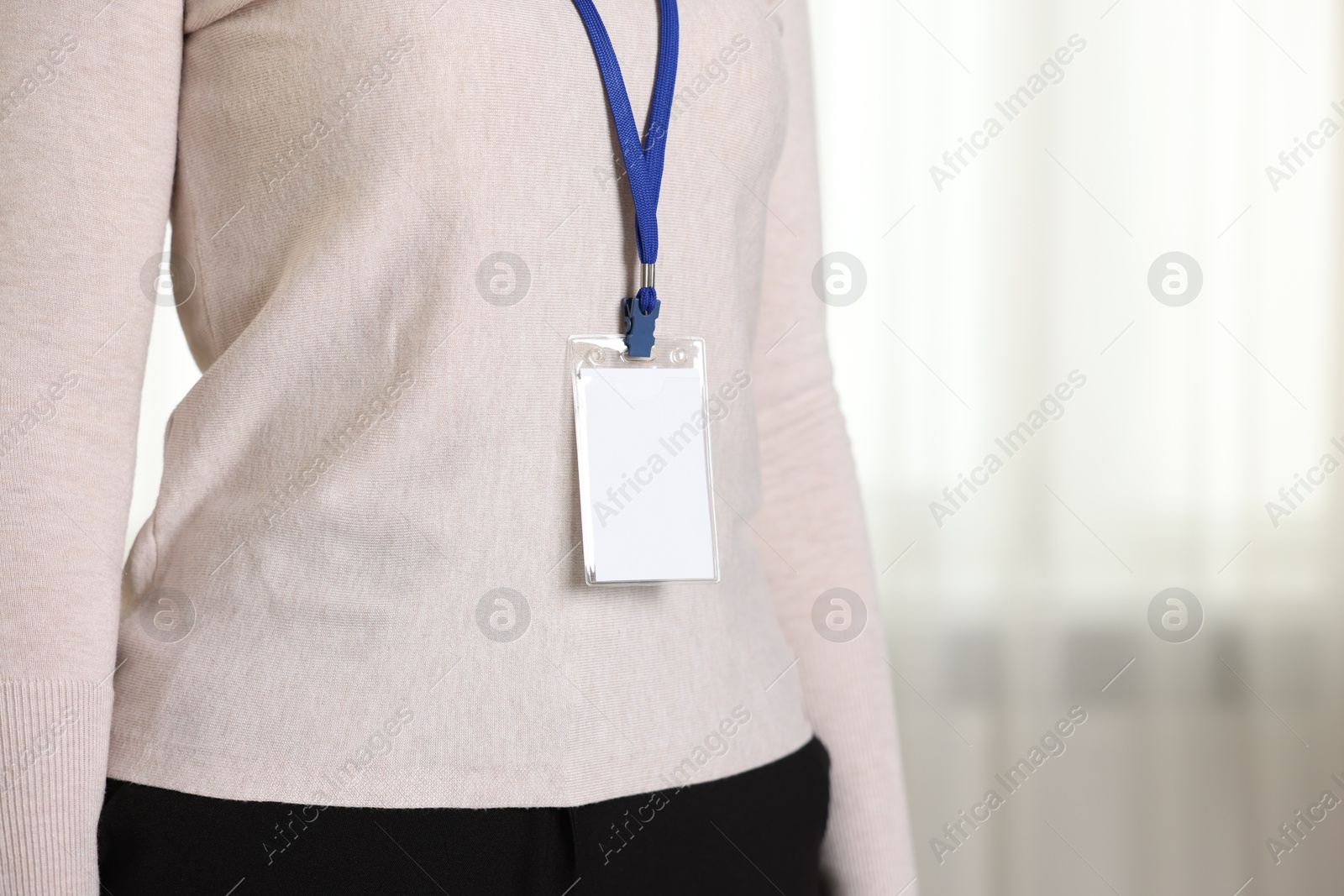 Photo of Woman with blank badge indoors, closeup. Space for text