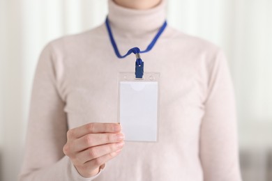 Photo of Woman with blank badge indoors, closeup view