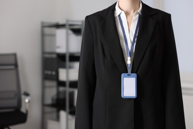 Photo of Woman with blank badge indoors, closeup view