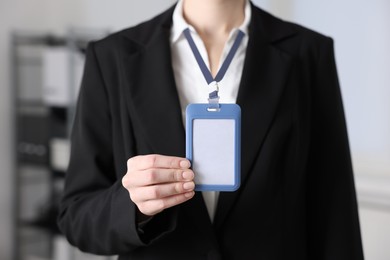 Photo of Woman with blank badge indoors, closeup view