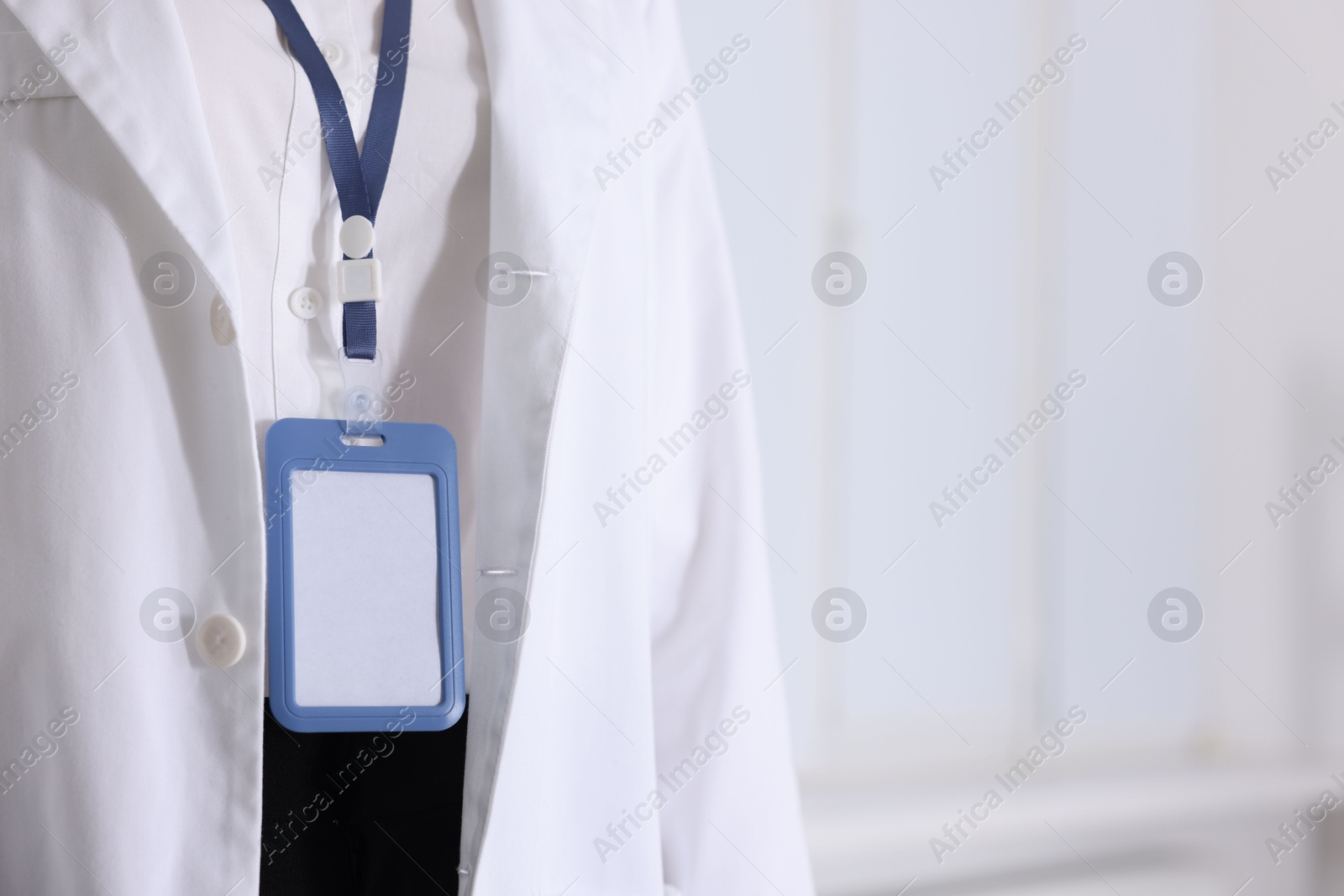 Photo of Doctor with badge in clinic, closeup. Space for text