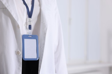 Photo of Doctor with badge in clinic, closeup. Space for text