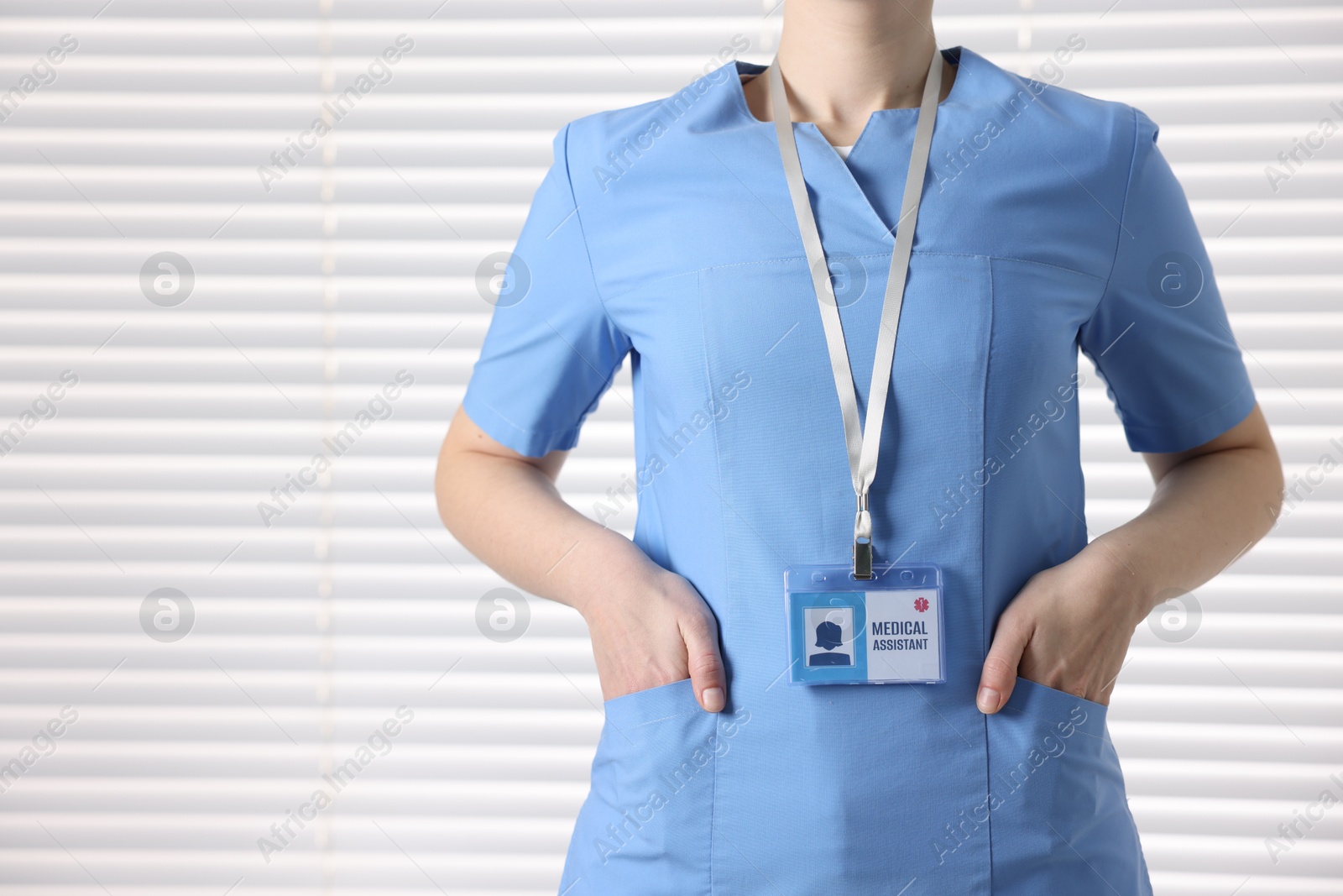 Photo of Medical assistant with badge in clinic, closeup. Space for text