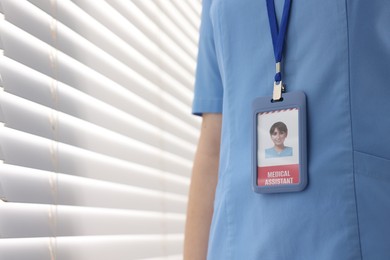 Medical assistant with badge in clinic, closeup. Space for text