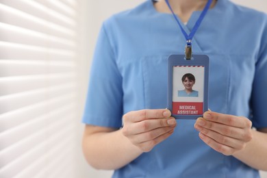 Medical assistant with badge in clinic, closeup. Space for text