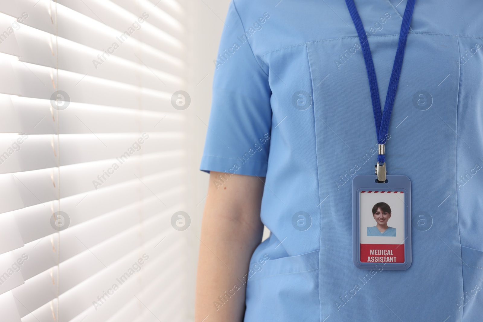 Photo of Medical assistant with badge in clinic, closeup. Space for text