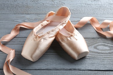 Photo of Pair of beautiful pointe shoes on grey wooden table