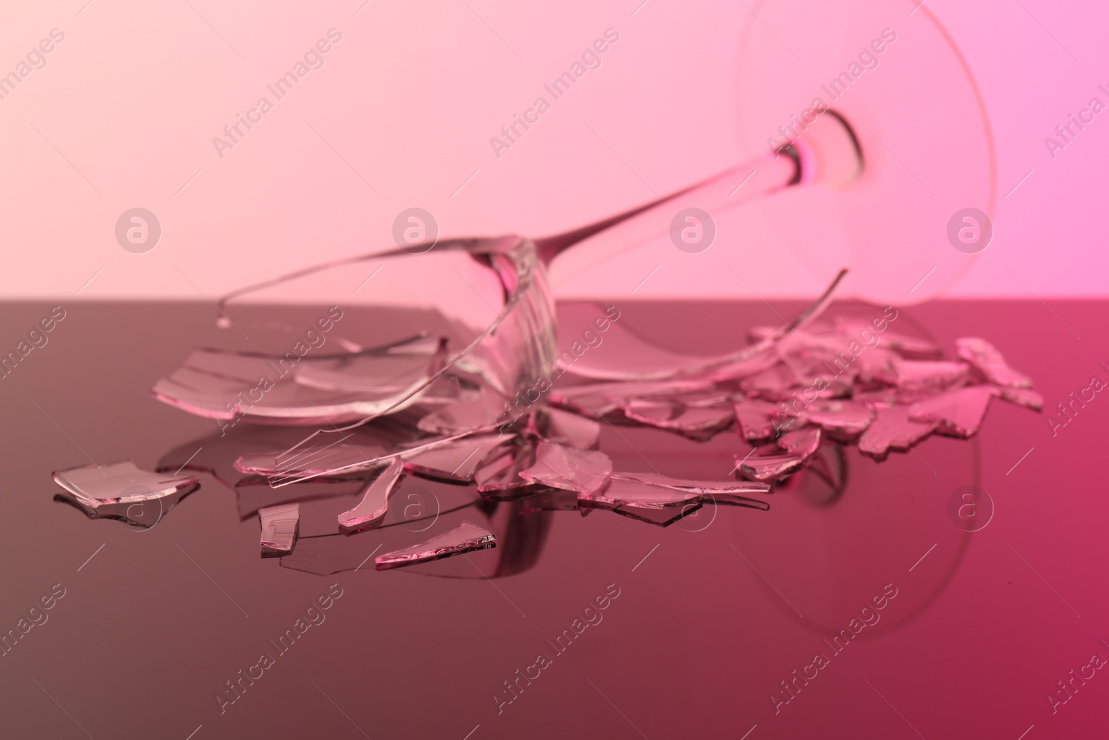 Photo of Pieces of broken wine glass on table, closeup. Color tone effect