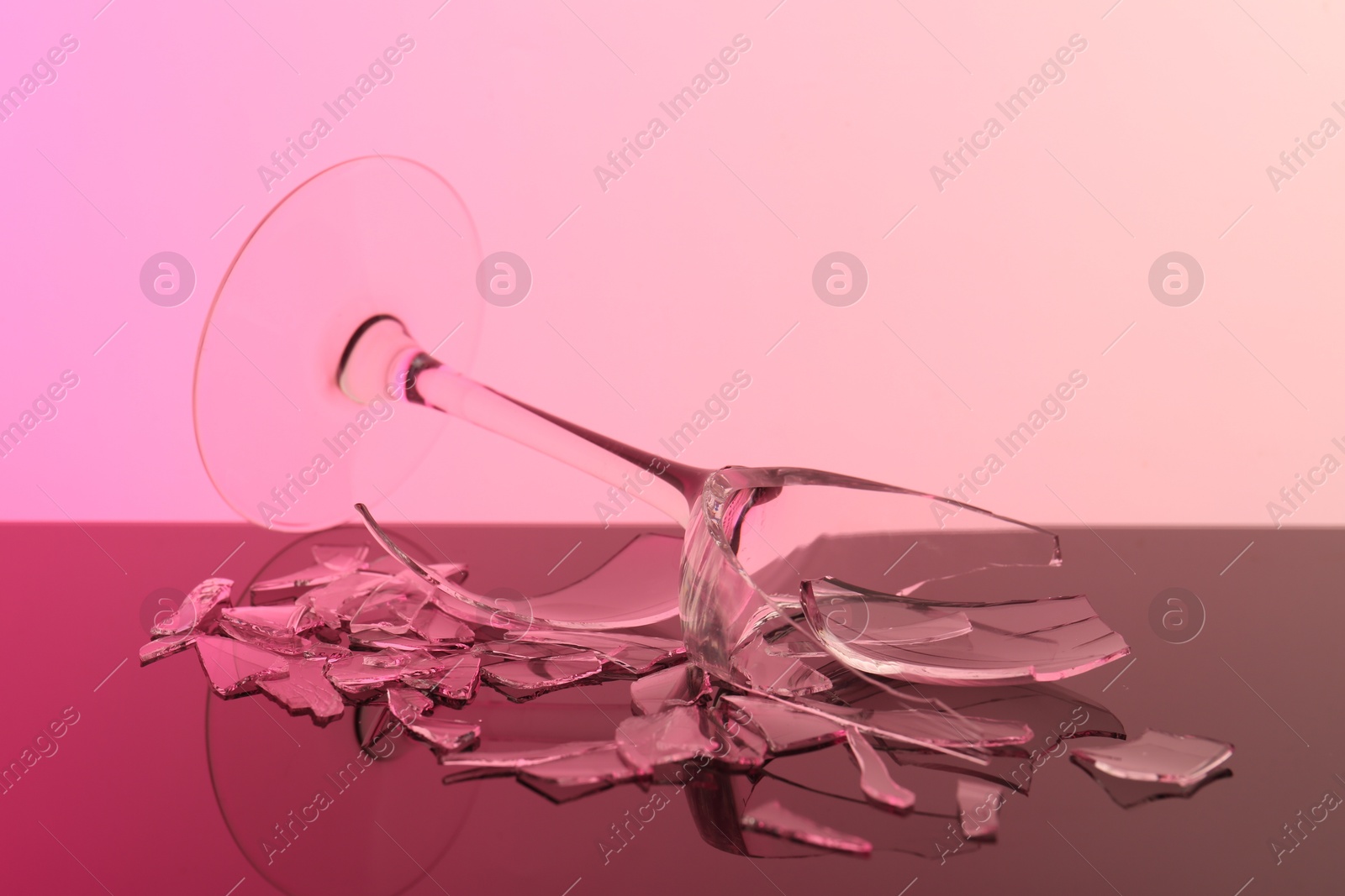 Photo of Pieces of broken wine glass on table, closeup. Color tone effect