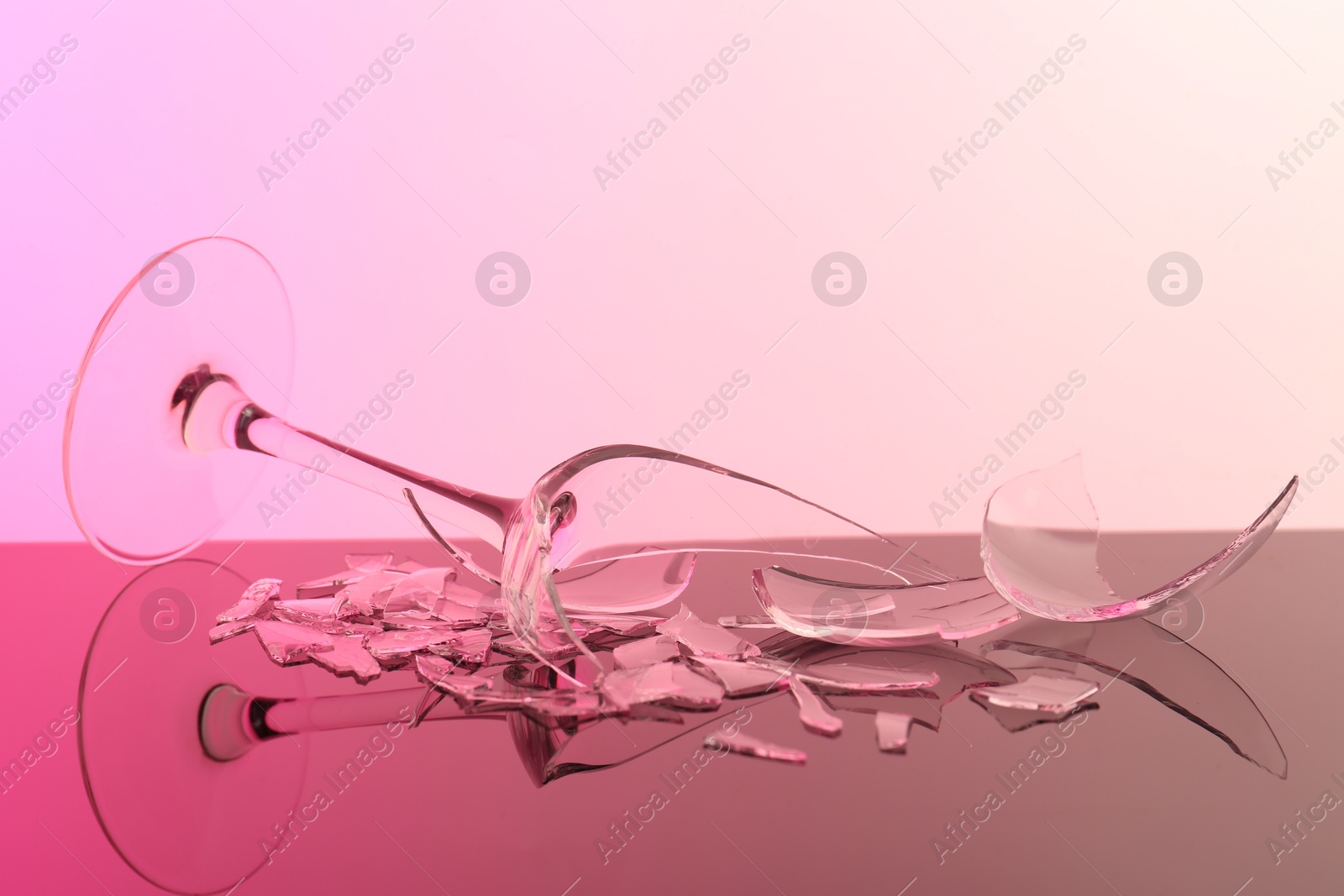 Photo of Pieces of broken wine glass on table, closeup. Color tone effect