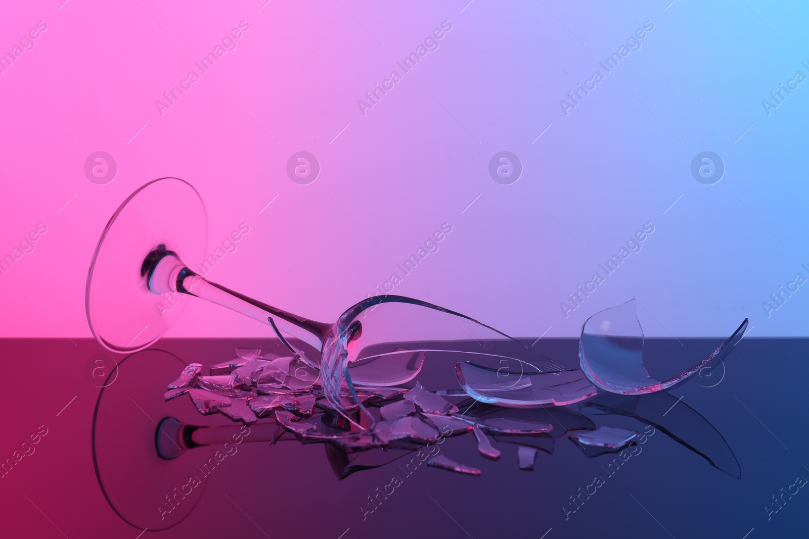 Photo of Pieces of broken wine glass on table, color tone effect