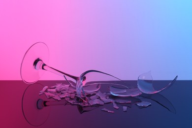 Photo of Pieces of broken wine glass on table, color tone effect