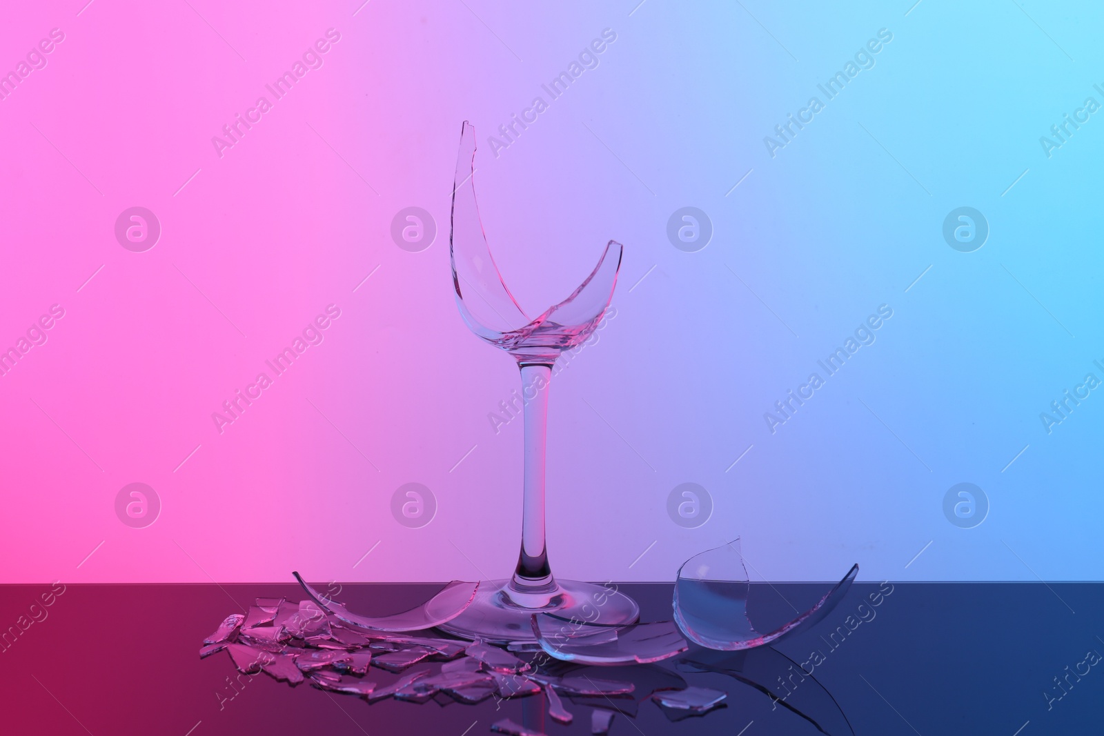 Photo of Pieces of broken wine glass on table, color tone effect