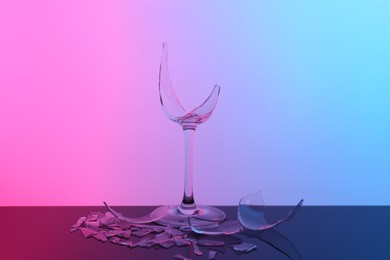 Photo of Pieces of broken wine glass on table, color tone effect