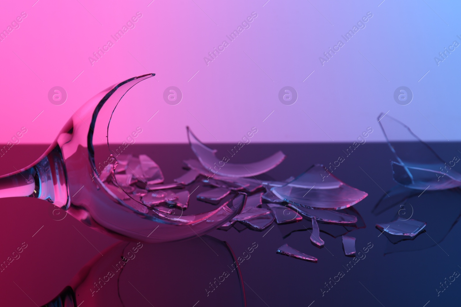 Photo of Pieces of broken wine glass on table, closeup. Color tone effect