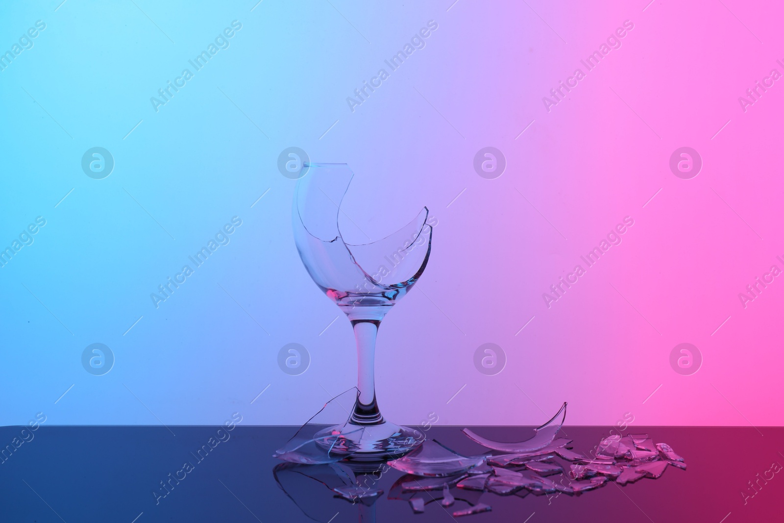 Photo of Pieces of broken wine glass on table, color tone effect