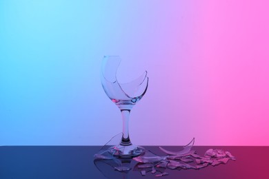 Photo of Pieces of broken wine glass on table, color tone effect