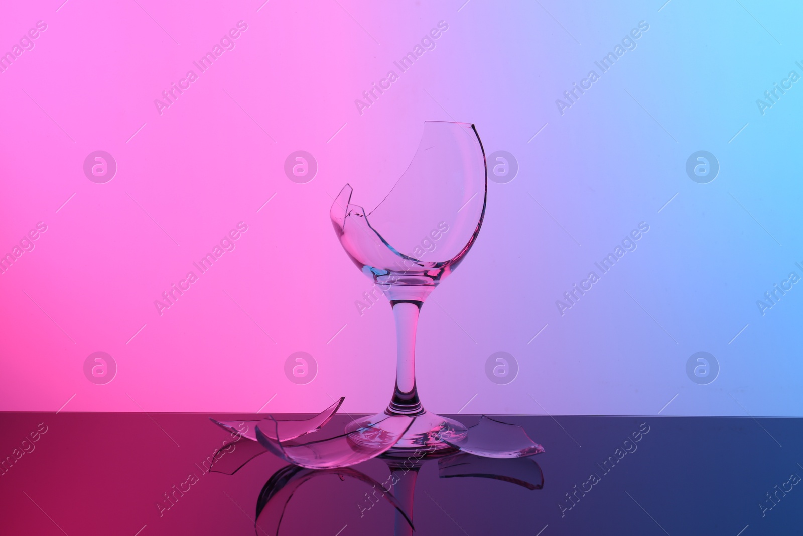 Photo of Pieces of broken wine glass on table, color tone effect