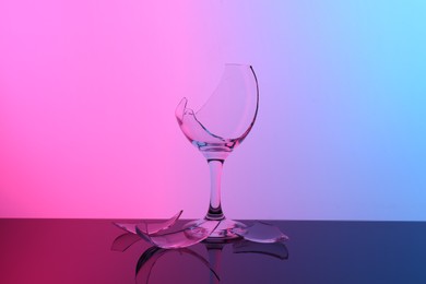 Photo of Pieces of broken wine glass on table, color tone effect