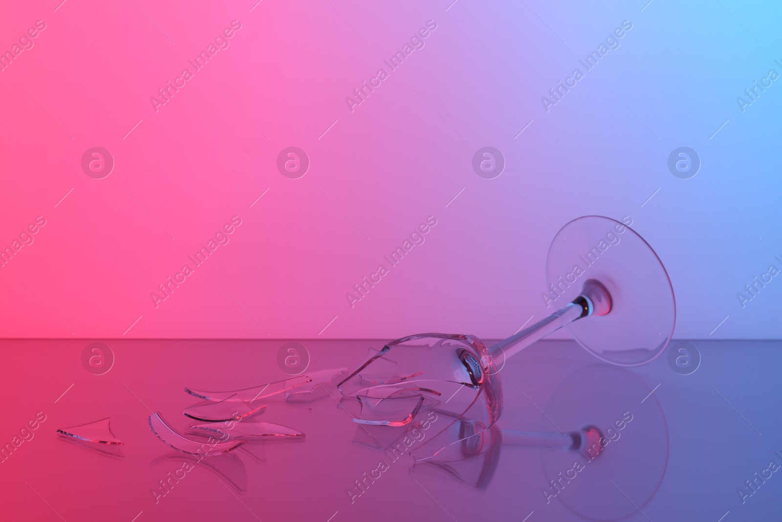 Photo of Pieces of broken wine glass on table, color tone effect