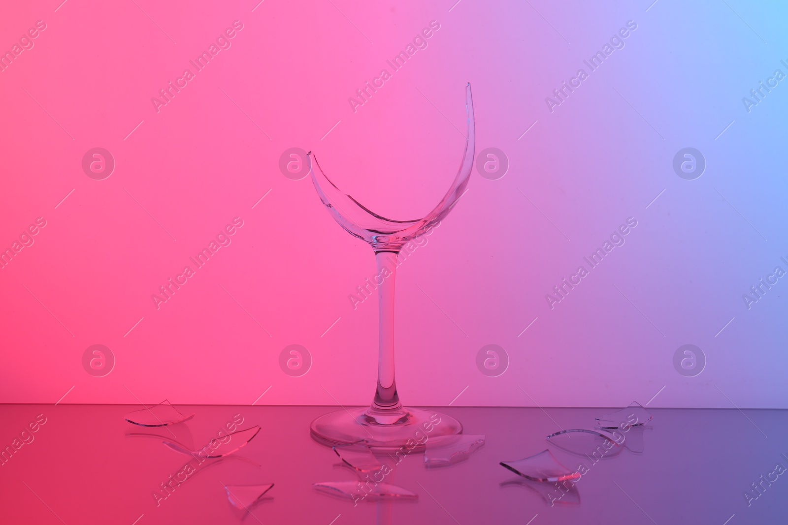 Photo of Pieces of broken wine glass on table, color tone effect