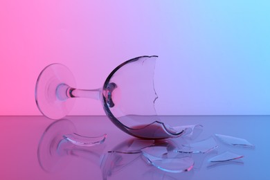 Photo of Pieces of broken glass with wine on table, closeup. Color tone effect