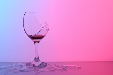 Photo of Pieces of broken glass with wine on table, space for text. Color tone effect