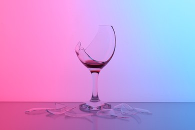 Photo of Pieces of broken glass with wine on table, color tone effect