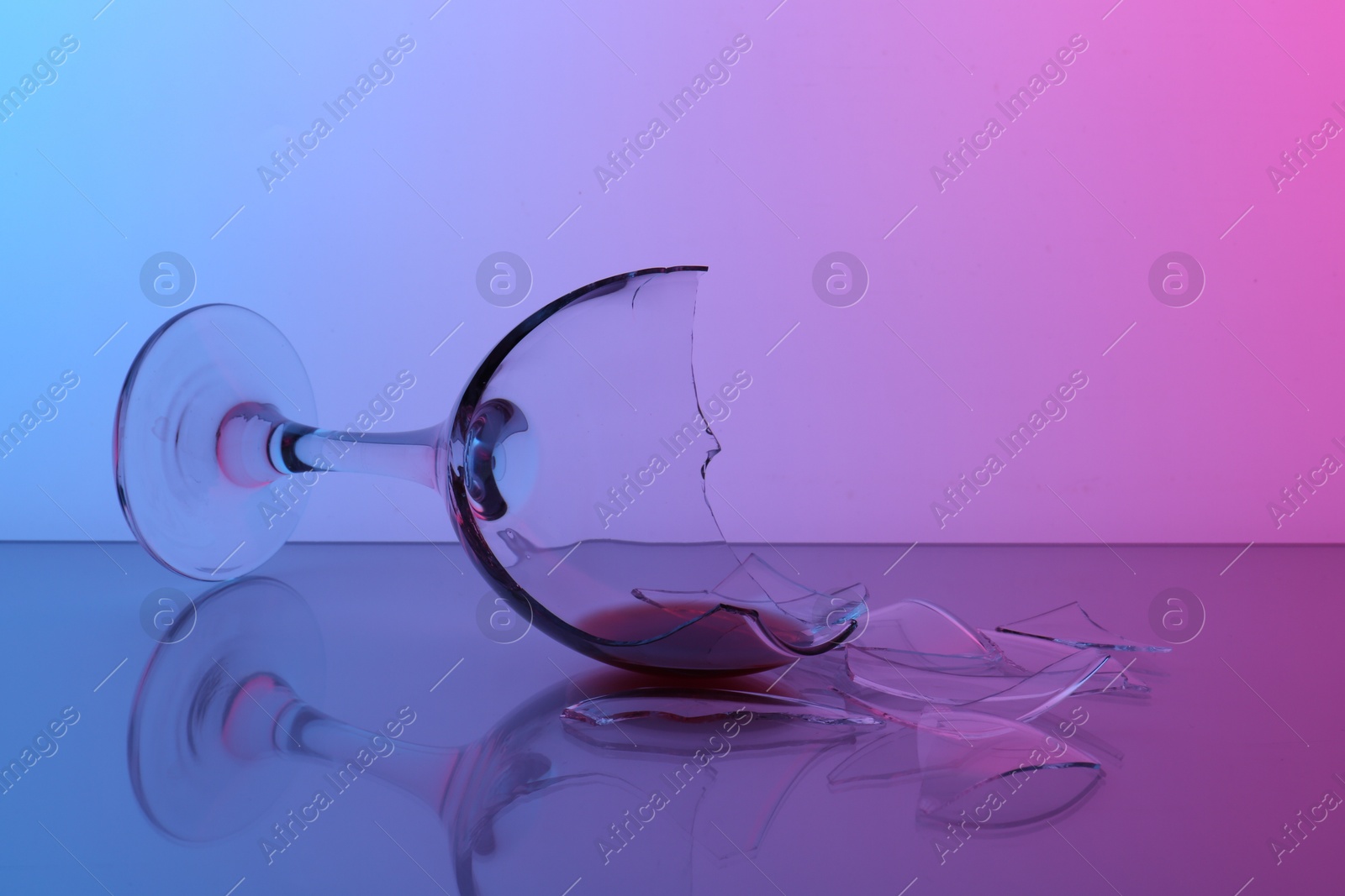 Photo of Pieces of broken glass with wine on table, closeup. Color tone effect