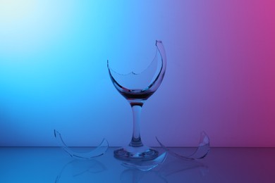 Photo of Pieces of broken glass with wine on table, color tone effect