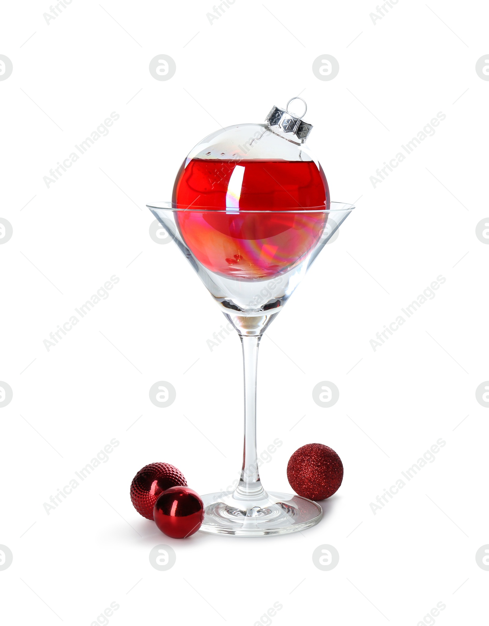 Photo of Presentation of Christmas cocktail in bauble and glass on white background