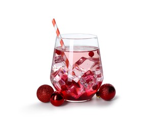 Photo of Tasty Christmas cocktail in glass and red baubles isolated on white