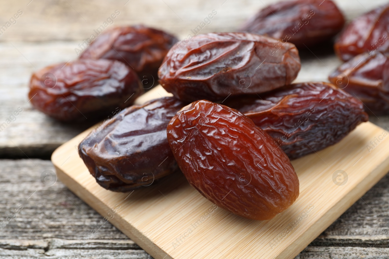 Photo of Many tasty dried dates on wooden table, closeup