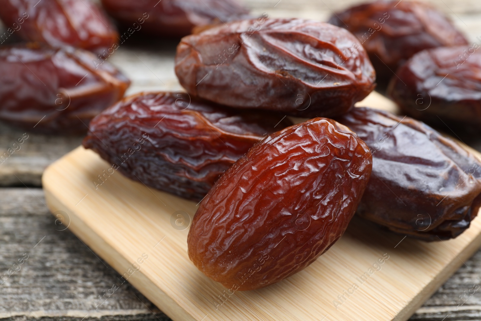 Photo of Many tasty dried dates on wooden table, closeup