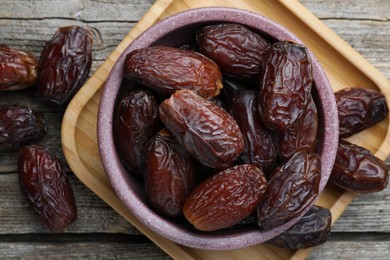 Photo of Many tasty dried dates in bowl on table, top view