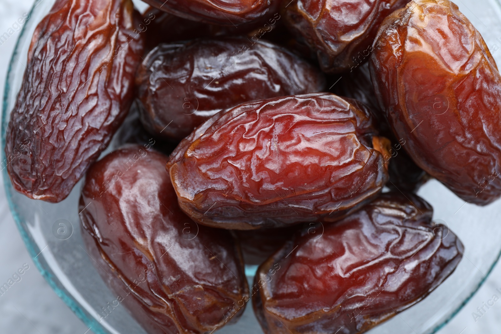 Photo of Many tasty dried dates in bowl on table, top view