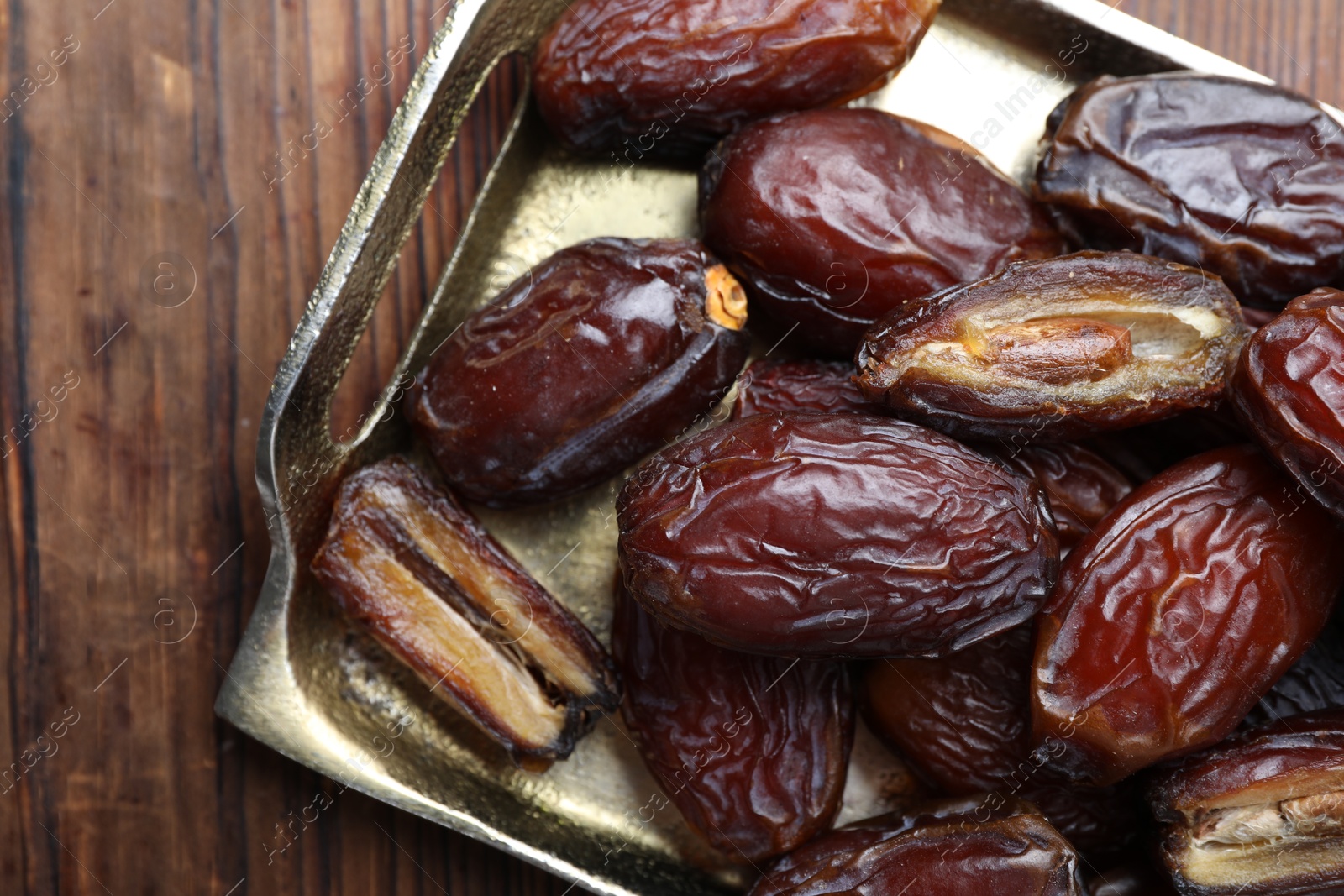 Photo of Many tasty dried dates on wooden table, top view