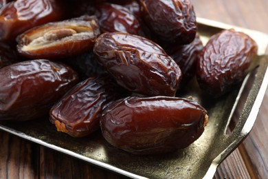 Photo of Many tasty dried dates on wooden table, closeup