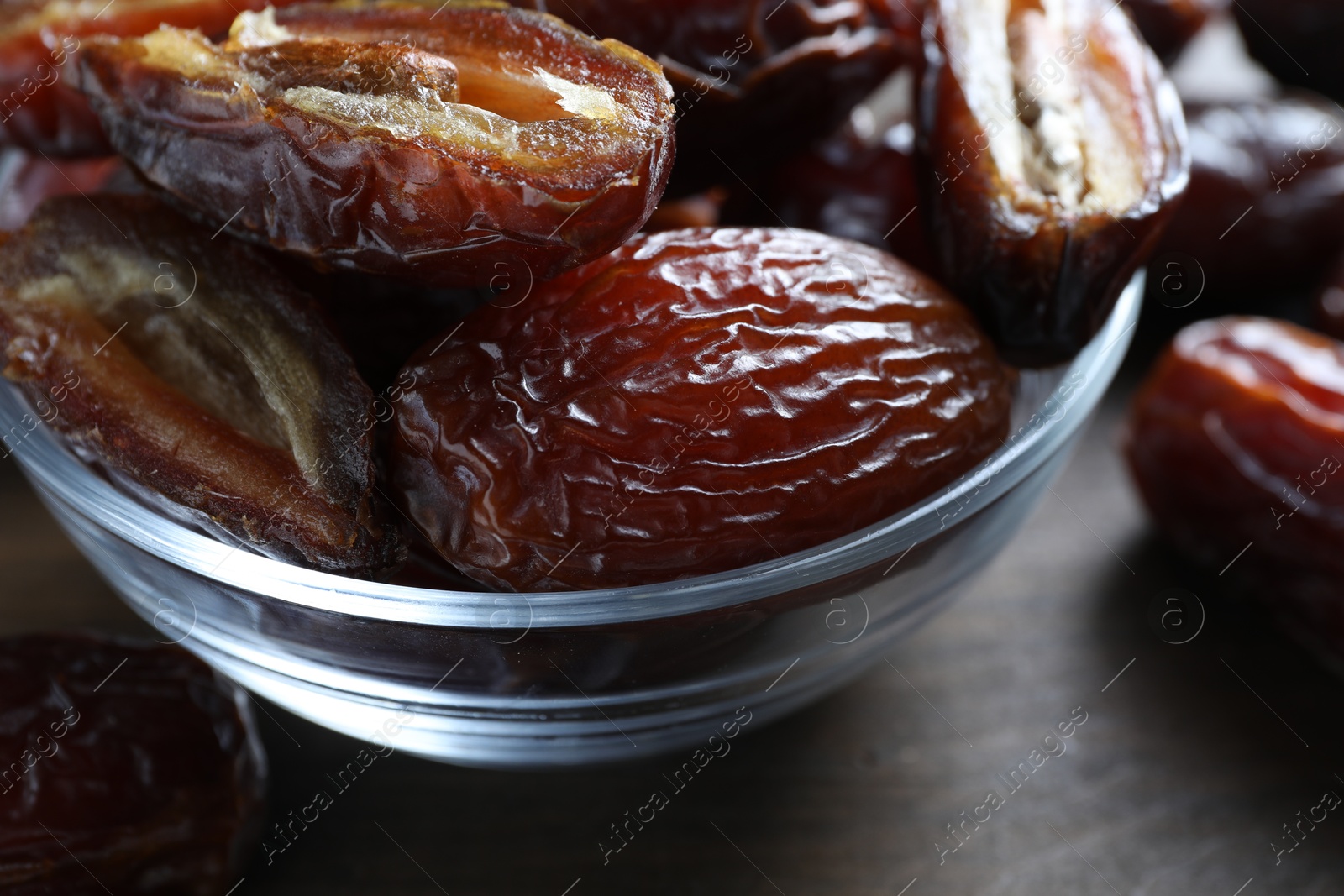 Photo of Many tasty dried dates in bowl on table, closeup