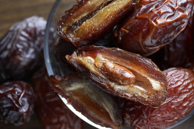 Photo of Many tasty dried dates in bowl on table, closeup