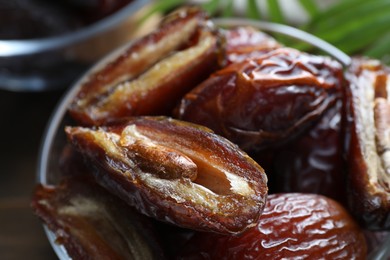 Photo of Many tasty dried dates in bowl on table, closeup