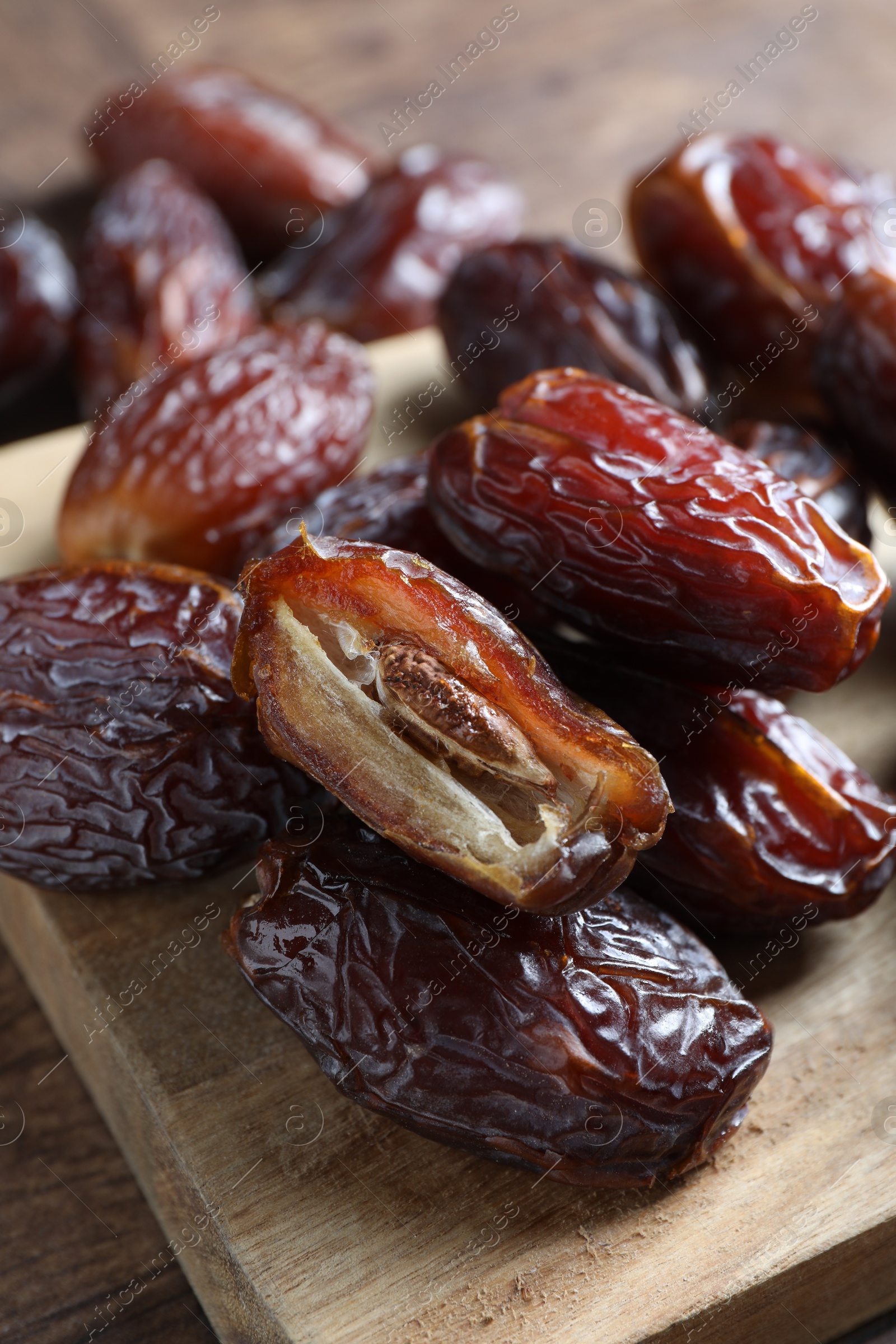 Photo of Many tasty dried dates on wooden table, closeup