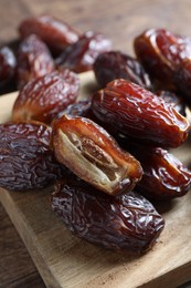 Photo of Many tasty dried dates on wooden table, closeup