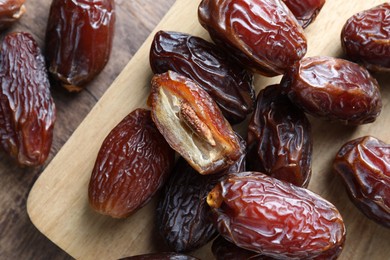 Photo of Many tasty dried dates on wooden table, top view