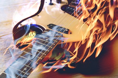 Image of Electric guitar in flames and smoke, closeup. Creative poster