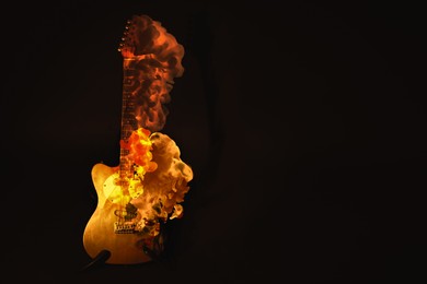 Image of Electric guitar burning on dark background, space for text. Creative poster