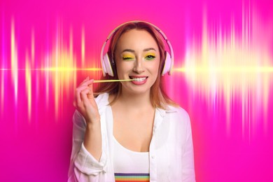 Image of Fashionable young woman with bright makeup and headphones listening to music on pink background. Sound waves behind her